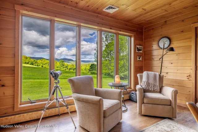 a living room with fireplace furniture and a large window