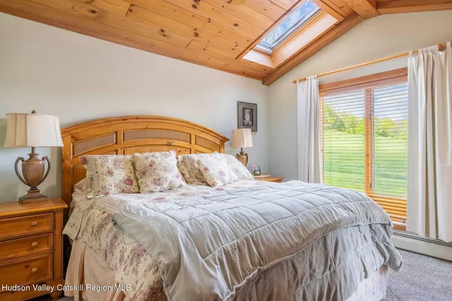 a living room with furniture a flat screen tv and a large window