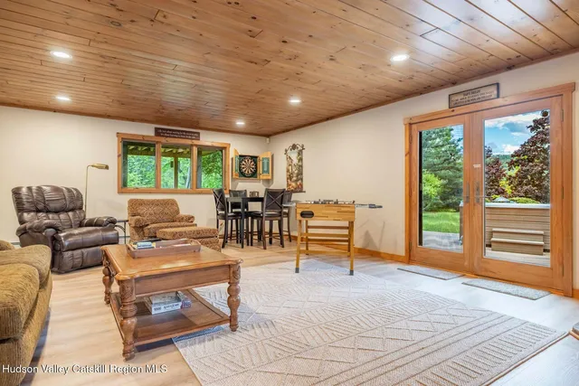 a roof deck with table and chairs potted plants with wooden floor and fence