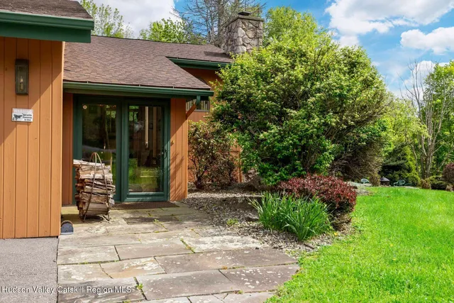 a living room with furniture a fireplace a chandelier and a large window