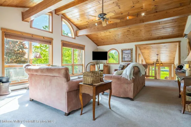 a living room with furniture a fireplace and a large window