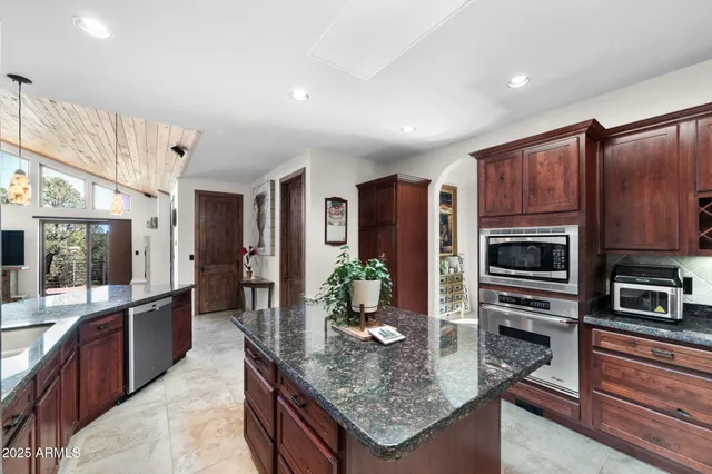a kitchen with stainless steel appliances granite countertop a stove refrigerator and cabinets