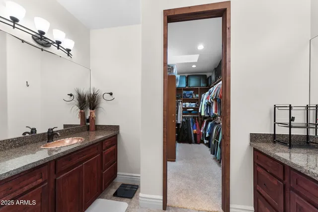 a en suite bathroom with a granite countertop sink and a mirror