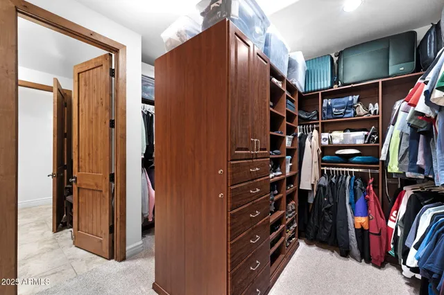 a view of walk in closet with clothes
