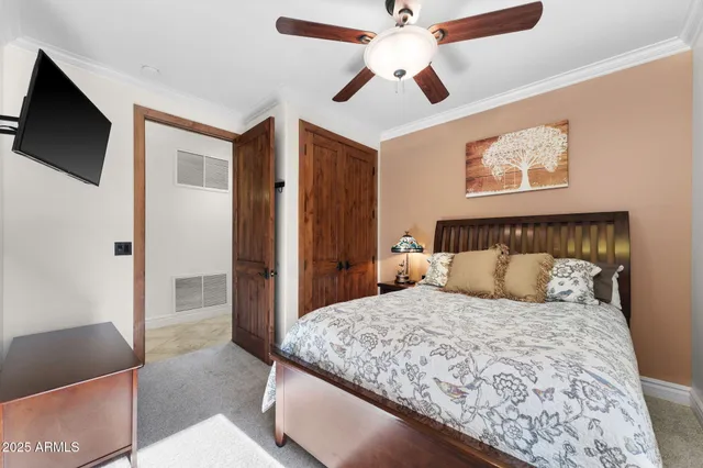 a bedroom with a large bed and a flat tv screen on a dresser