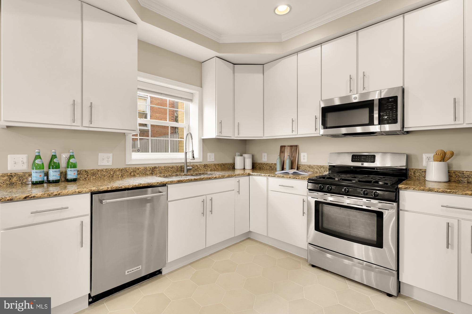 1923 1st Street Northeast Washington, DC 20002 - Photo 7 of 42 a kitchen with granite countertop white cabinets and white stainless steel appliances