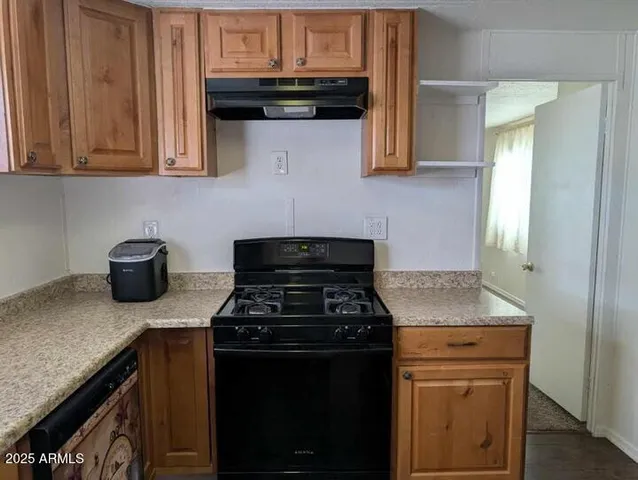 a kitchen with granite countertop stainless steel appliances a stove microwave and cabinets