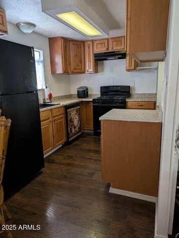 a kitchen with stainless steel appliances granite countertop a refrigerator a stove and a sink