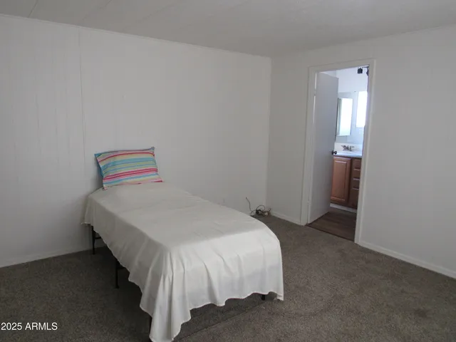 a bed sitting in a bedroom next to a bathroom