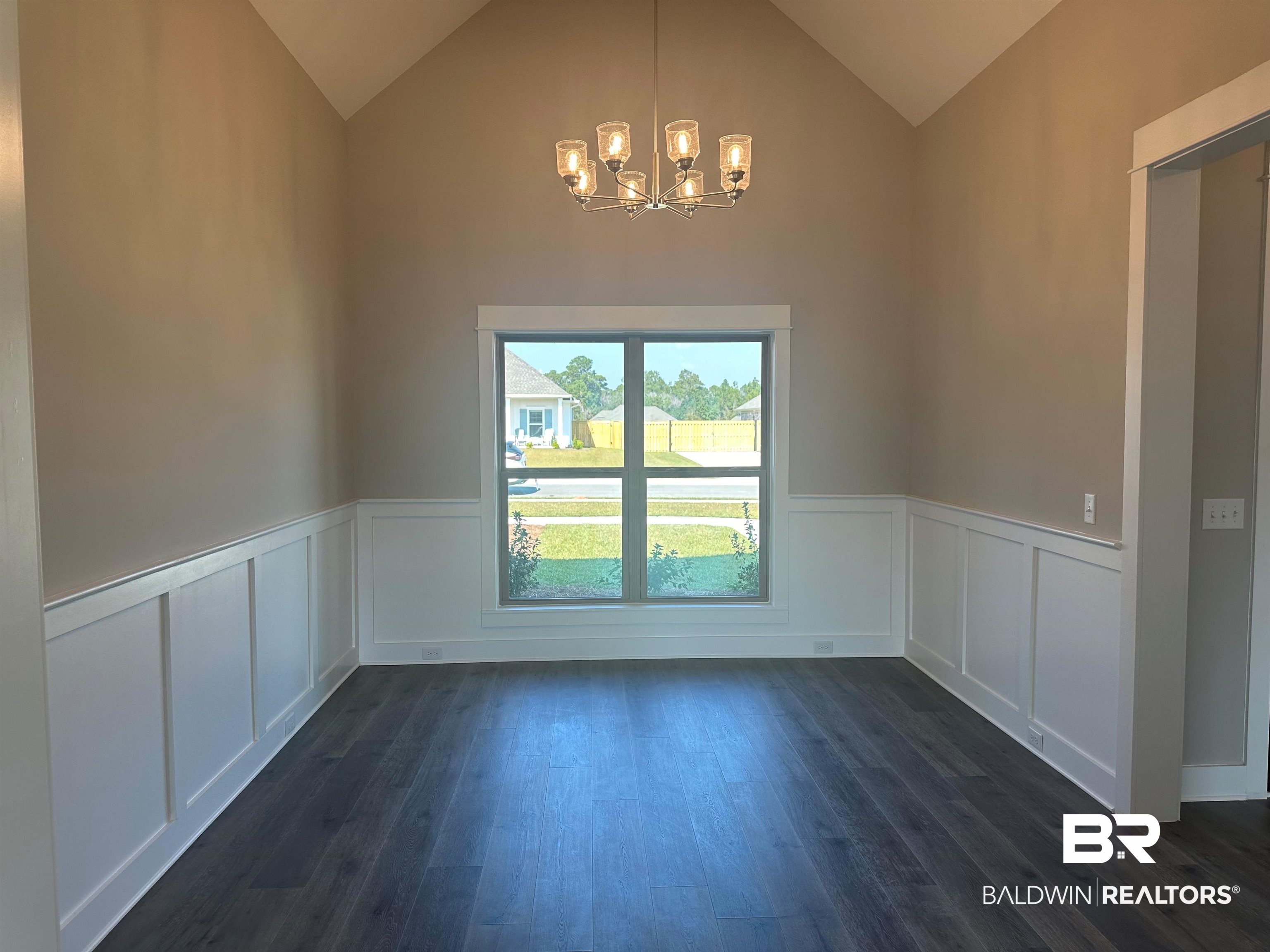 23548 Travis Stock Street, Unit 50 Foley, AL 36535 - Photo 10 of 30 Unfurnished dining area with high vaulted ceiling, dark hardwood / wood-style floors, and an inviting chandelier