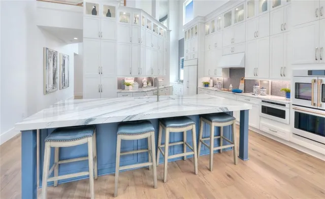 a large kitchen with stainless steel appliances lots of counter space and wooden floor