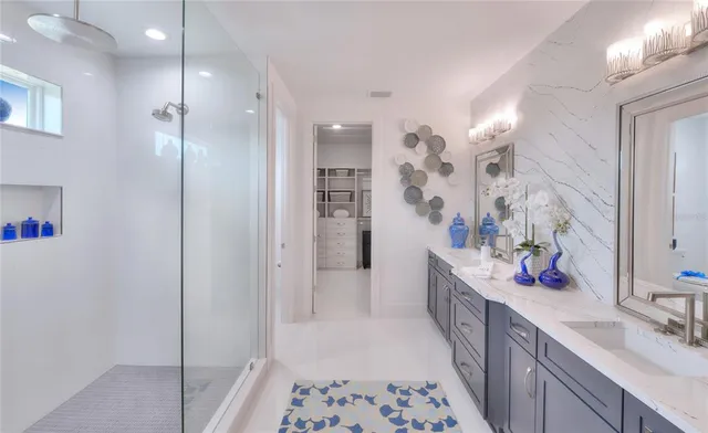 a bathroom with a double vanity sink mirror and shower