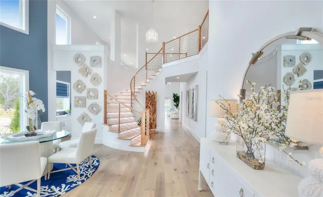 a view of a dining room with furniture a potted plant and wooden floor