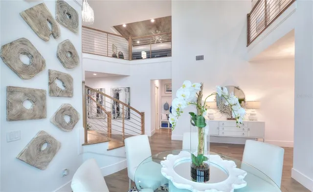 a kitchen with stainless steel appliances kitchen island granite countertop a table chairs in it and white cabinets