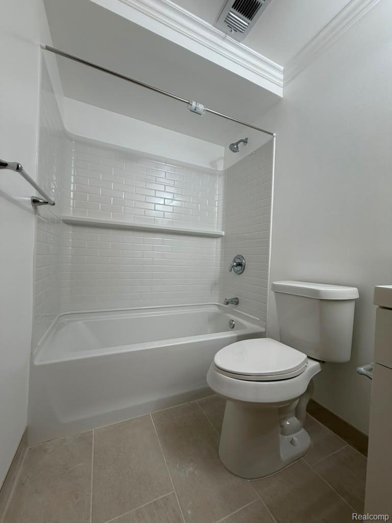 43284 Mound Road Sterling Heights, MI 48314 - Photo 8 of 19 Bathroom featuring a white subway tile shower surround with integrated shelving, chrome fixtures, a complete toilet, light-toned rectangular floor tiles, and crown molding