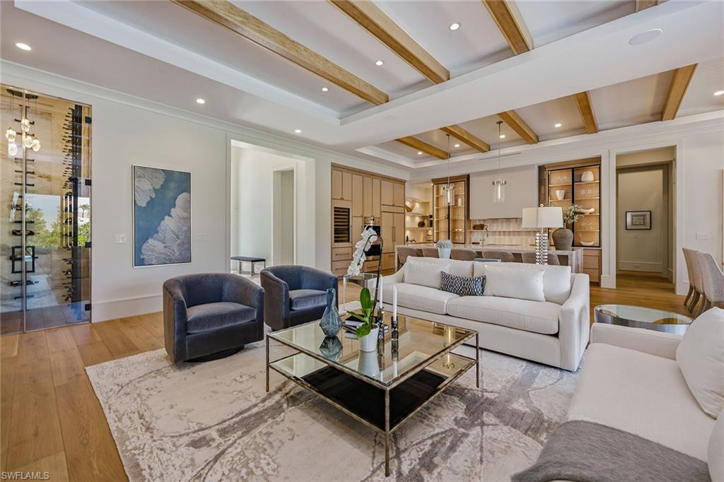 529 Neapolitan Way Naples, FL 34103 - Photo 5 of 26 a living room with furniture a rug kitchen view and a large window