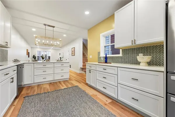 a large white kitchen with cabinets
