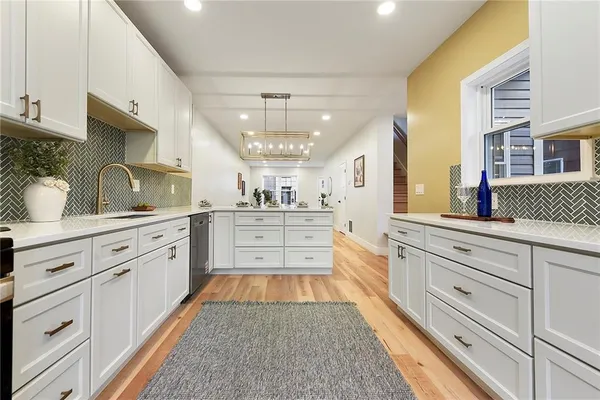 a large white kitchen with cabinets
