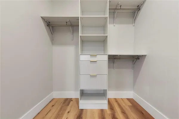 a view of walk in closet with empty racks