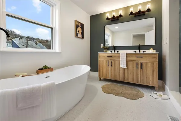 a bathroom with a double vanity sink mirror and bathtub