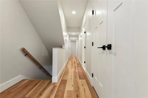 a view of a hallway with wooden floor and staircase