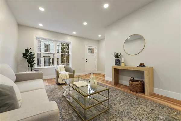 a living room with furniture a fireplace and a potted plant