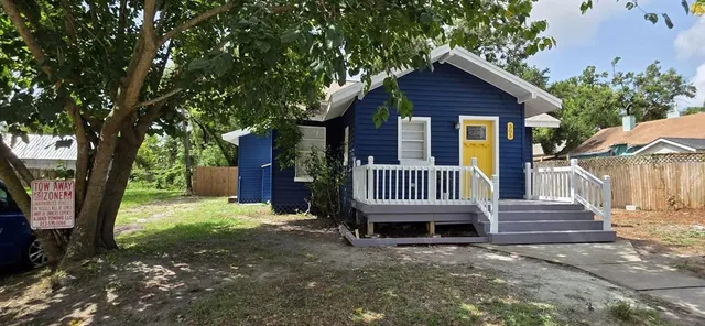 a view of a house with a yard and wooden fence