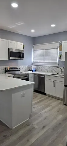 a kitchen with stainless steel appliances a sink and a stove top oven