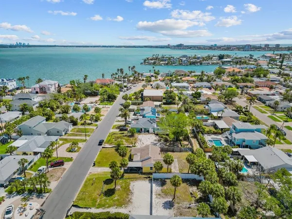 an aerial view of a city with lots of residential buildings ocean and mountain view in back