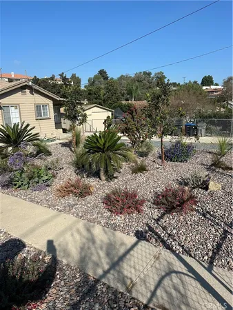 a view of a dry yard with wooden fence