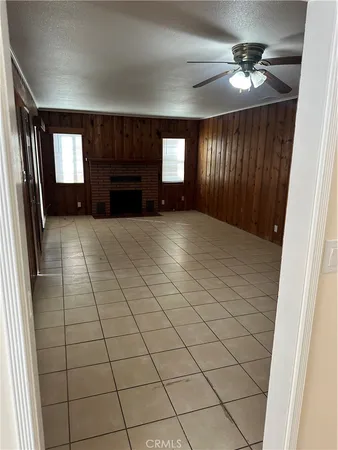 a view of an empty room with a fireplace and a window