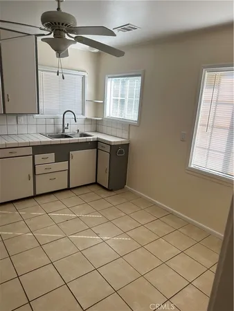 a large white tub sitting in a kitchen next to a window