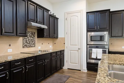 a kitchen with stainless steel appliances granite countertop a refrigerator stove and sink