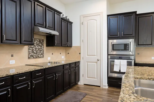 a kitchen with stainless steel appliances granite countertop a refrigerator stove and sink