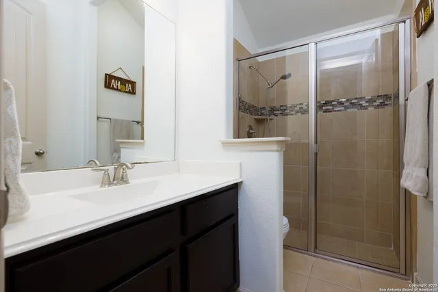 a bathroom with a shower sink and mirror