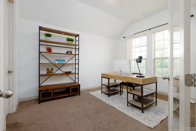 a view of a workspace with furniture and a window