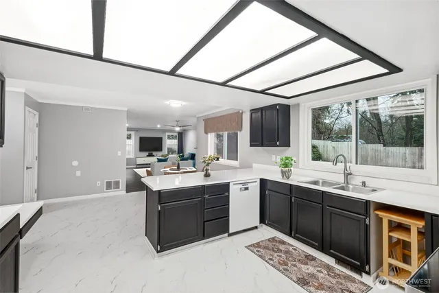 a large white kitchen with a sink and cabinets