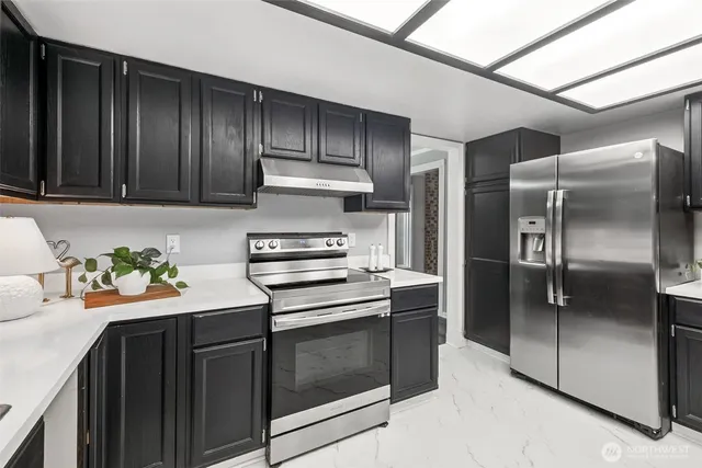 a kitchen with stainless steel appliances granite countertop a refrigerator and a sink