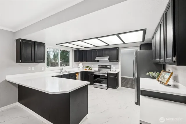 a kitchen with stainless steel appliances kitchen island granite countertop a sink counter space and cabinets
