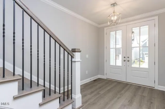a view of an empty room with wooden floor fireplace and a window