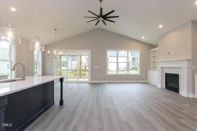 a large white kitchen with large window and stainless steel appliances