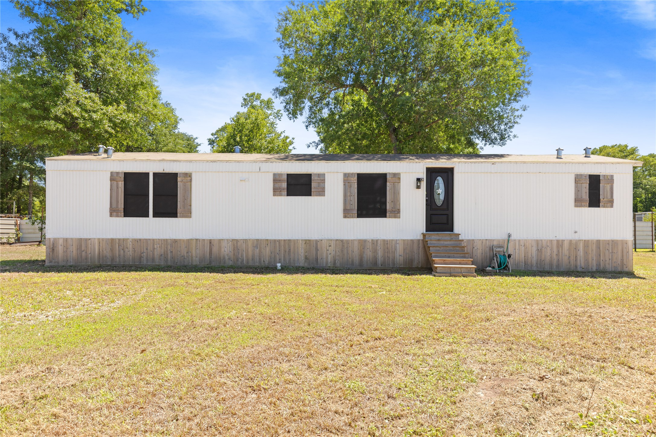 2134 County Road 5017 Cleveland, TX 77327 - Photo 2 of 25 a view of a house with a yard and a large tree