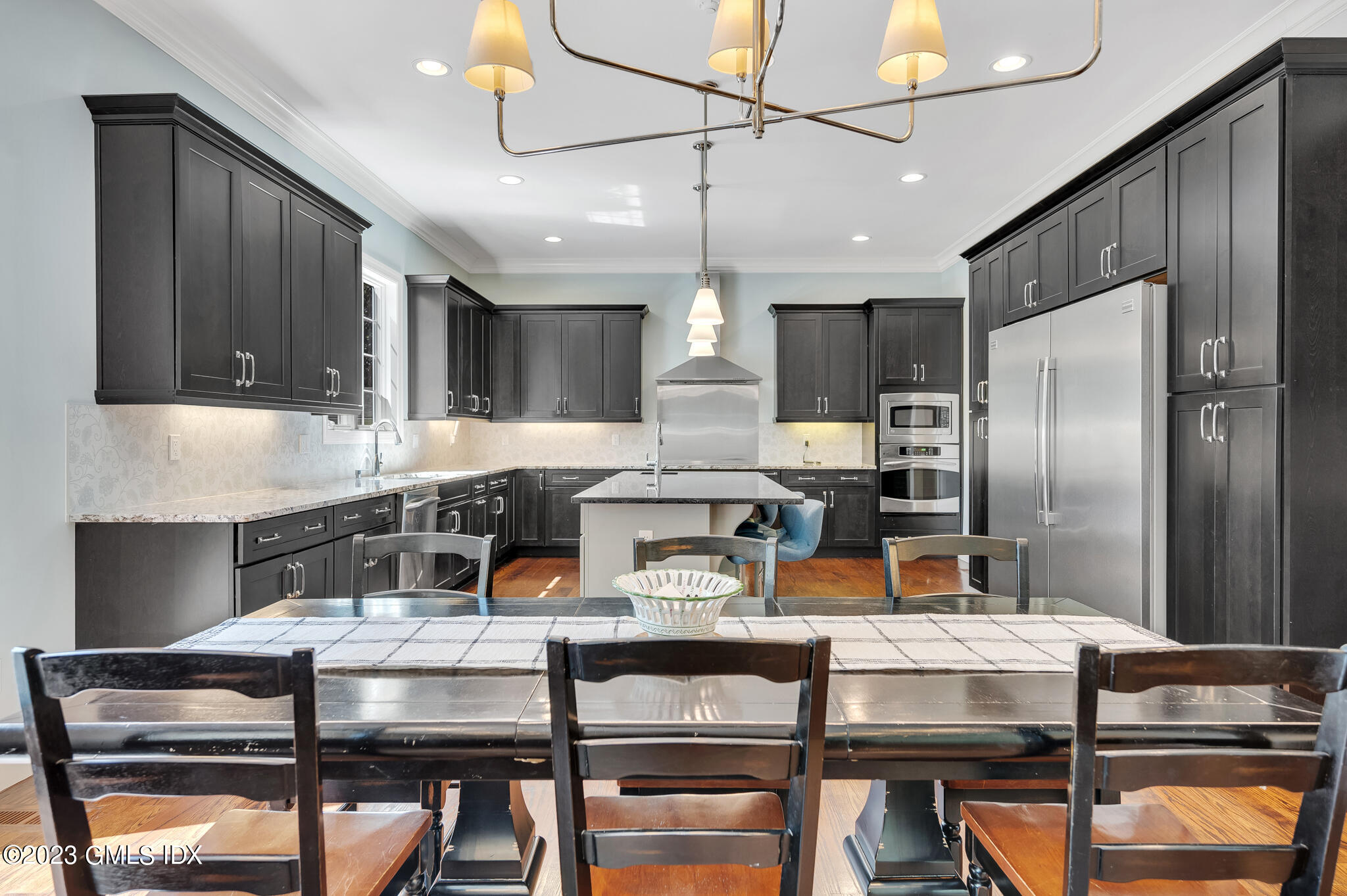 58 Perkins Road Greenwich, CT 06830 - Photo 3 of 30 a kitchen with a table chairs refrigerator and microwave