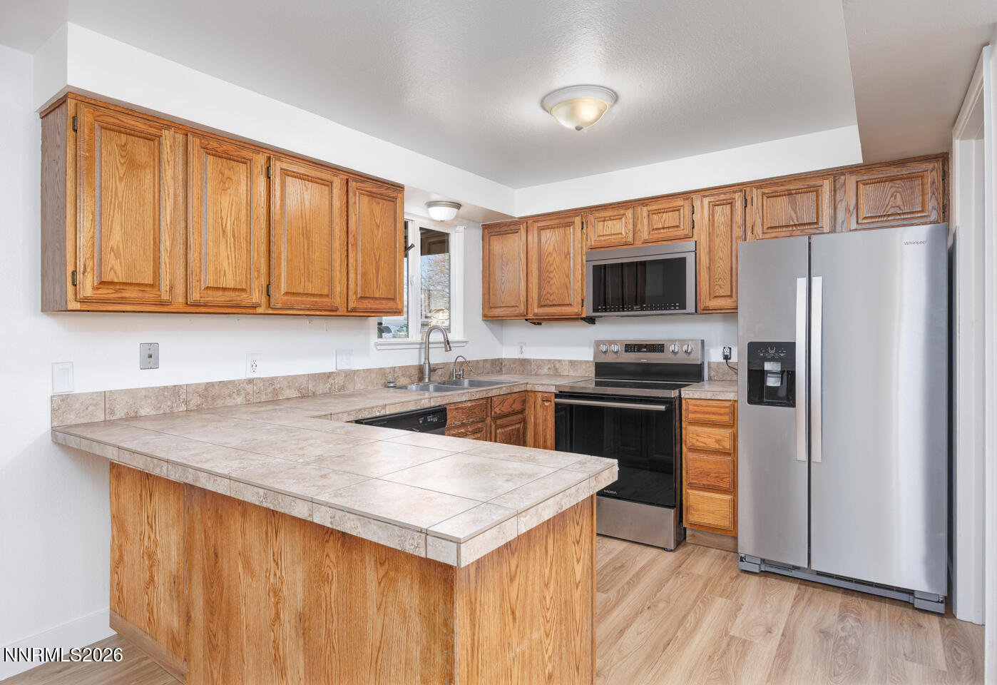 590 Fargo Way Fernley, NV 89408 - Photo 5 of 25 a kitchen with a refrigerator a microwave a sink and white cabinets