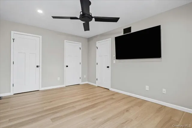 a view of room with wooden floor and chandelier fan