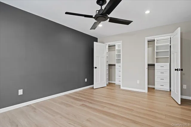 an empty room with closet and a ceiling fan