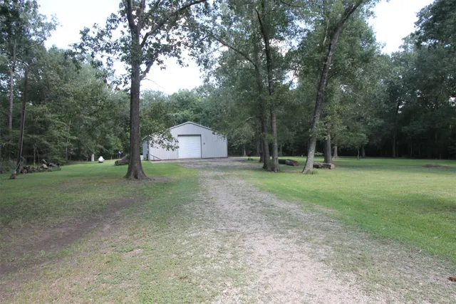 a view of a house with backyard and trees