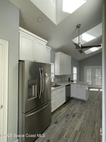 a kitchen with granite countertop a refrigerator stove and sink