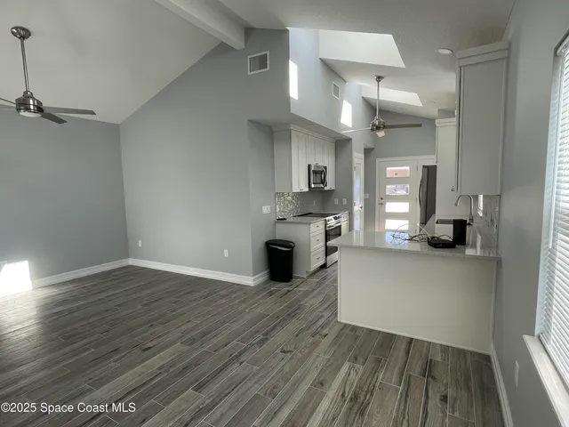 a view of a kitchen with cabinets and wooden floor