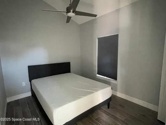 a bed sitting in a bedroom and wooden floor